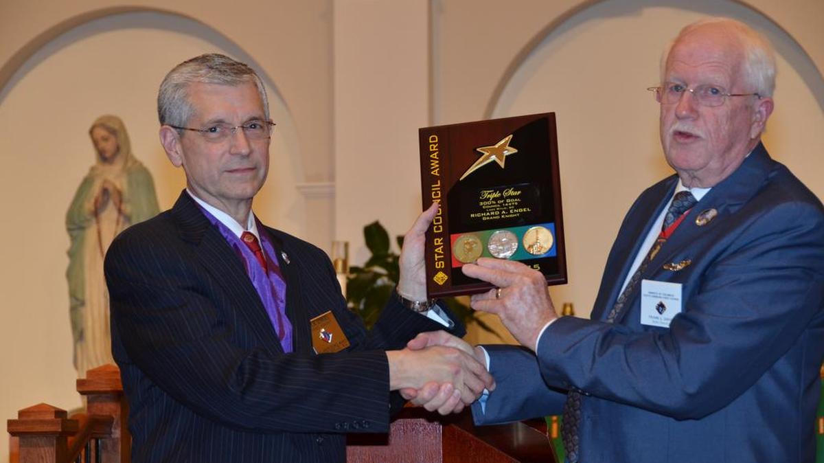 Rick Engel, left, Grand Knight of All Saints Council No. 14475, is presented the Triple Star Award by Knights of Columbus State Deputy Frank Davis. Engel attributes his council’s success to “the great group of ordinary guys selflessly doing ordinary things to support their parish and community ... and more Catholic gentlemen wanting to become part of what we are doing every day.”