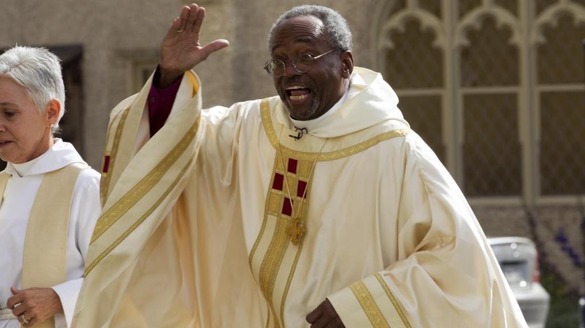 Episcopal Church Presiding Bishop-elect Michael Curry gives waves to the crowd as he arrives at the Washington National Cathedral.