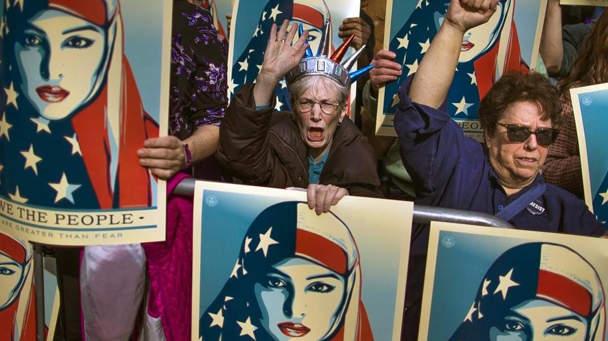 People carry posters during a rally against President Donald Trump's executive order banning travel from seven Muslim-majority nations, in New York's Times Square on Feb. 19.