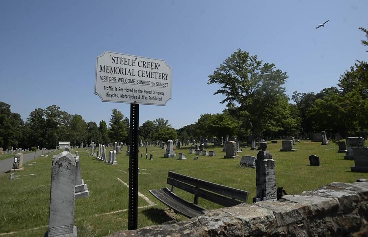 An airplane flies over the cemetery at Steele Creek Presbyterian Church on Friday.