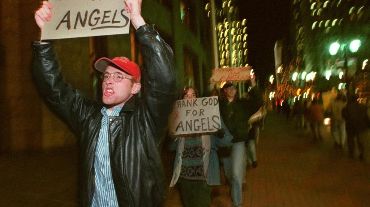 Protesters march along North Tryon Street in front of the Performing Arts Center in March 1996. A last-minute court order secured the 10-day run of the show.