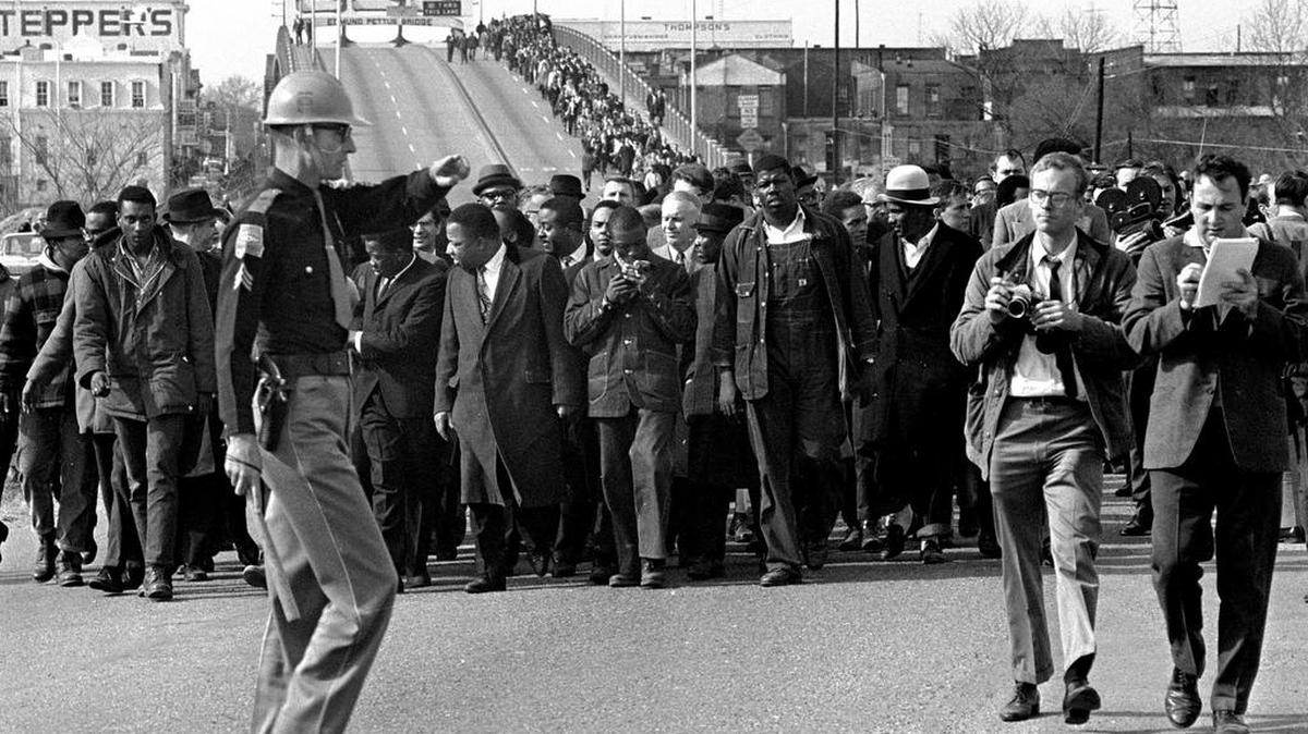 In this March 10, 1965 photo, demonstrators, including Dr. Martin Luther King, Jr., stream over an Alabama River bridge at the city limits of Selma, Ala., during a voter rights march. King’s participation in the 54-mile march from Selma, Ala., to the state capital of Montgomery elevated awareness about the troubles blacks faced in registering to vote.