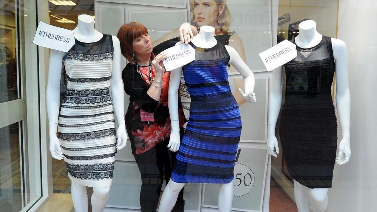 In this Feb. 27, 2015 file photo, shop manager Debbie Armstrong adjusts a two tone Roman Originals dress in a window display at a Roman Originals shop in Lichfield, England. Over the course of a few days, the debate over whether the dress sold by Roman Originals, a U.K. clothing-store chain, was blue and black or white and gold stirred social networks and led to a frenzy that extended to traditional media.