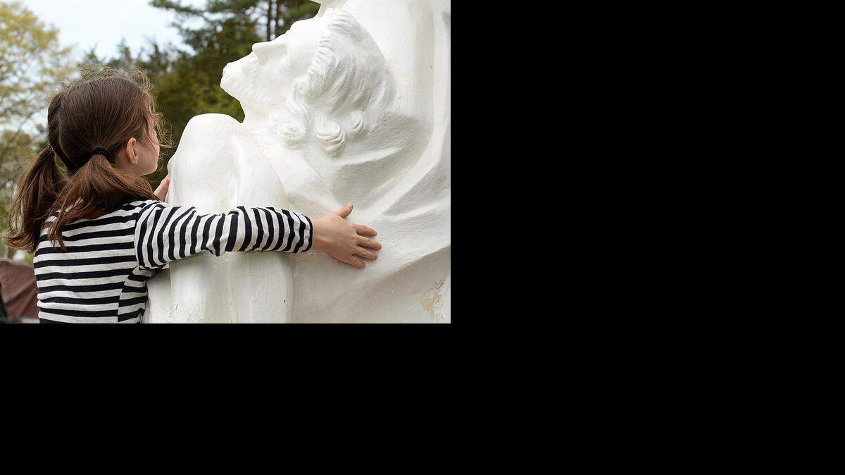 
Bayley Tonucci, 9, touches the statue of Christ as she walks the Stations of the Cross at St. Joseph Vietnamese Catholic Church on Friday March 3, 2015. On Good Friday, Catholics and Protestants marked Jesus' death on the cross. Many churches relive Jesus' suffering, or Passion, via a step-by-step ritual with art and statues called Stations of the Cross. Charlotte's St. Joseph Vietnamese Catholic Church has life-size Stations of Jesus, the Roman soldiers and others outdoors. On Good Friday, the church's priests and members performed the Stations outside, just to the side of the church, with these life-size representations.
