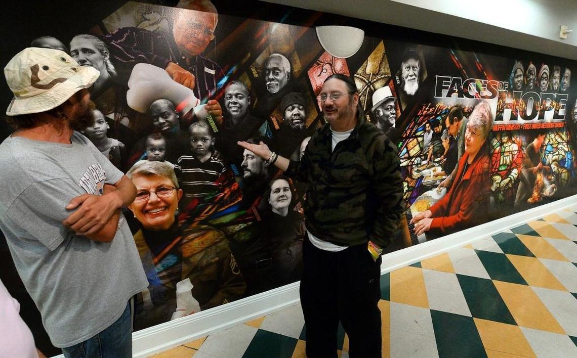 Adam Mayhew, left and Paul Lessard, right, talk about the “Faces of Hope” mural at uptown Charlotte’s First United Methodist Church. The photographed faces of both of them are included in the 30 ft x 8 ft work of art. The mural features 50 portraits in celebration of the church’s Sunday morning ministry feeding the homeless. Mayhew and Lessard are both volunteers. Lessard is also homeless.