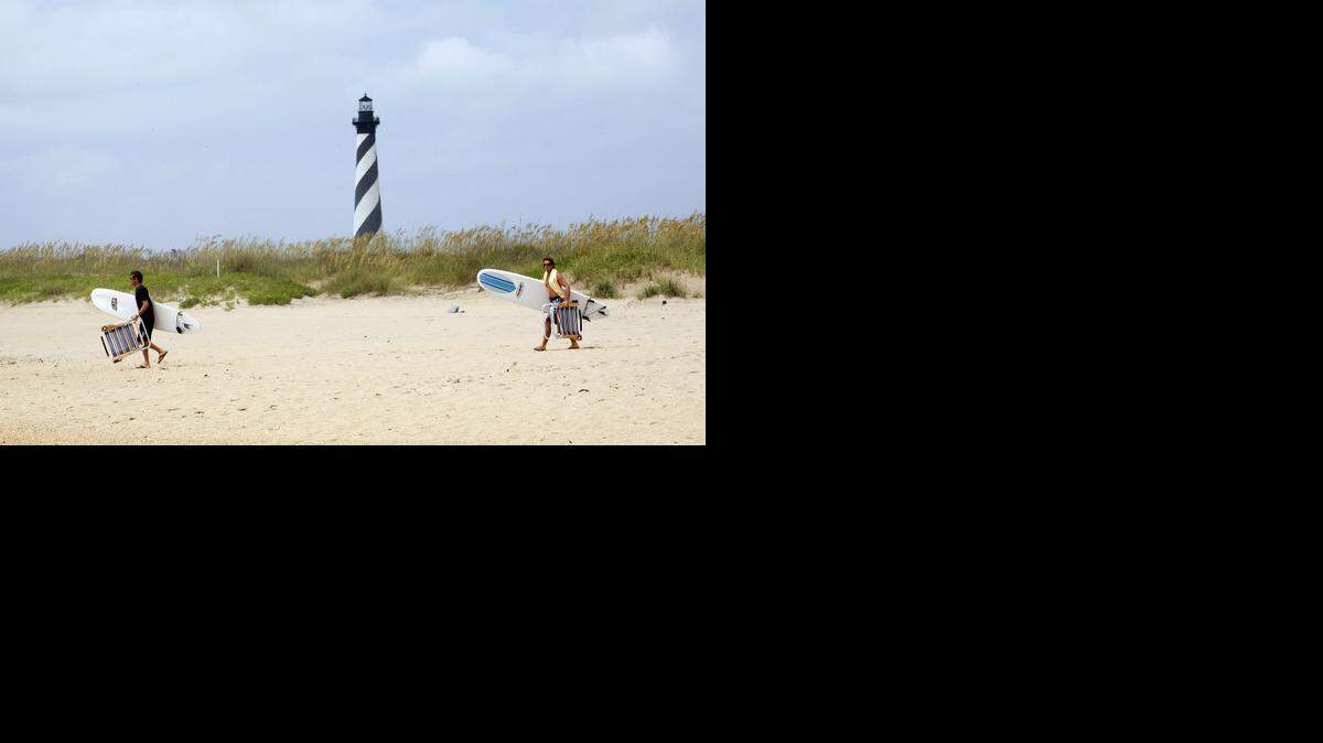 
2008 file – Visitors walk on the beach near Cape Hatteras Lighthouse.
