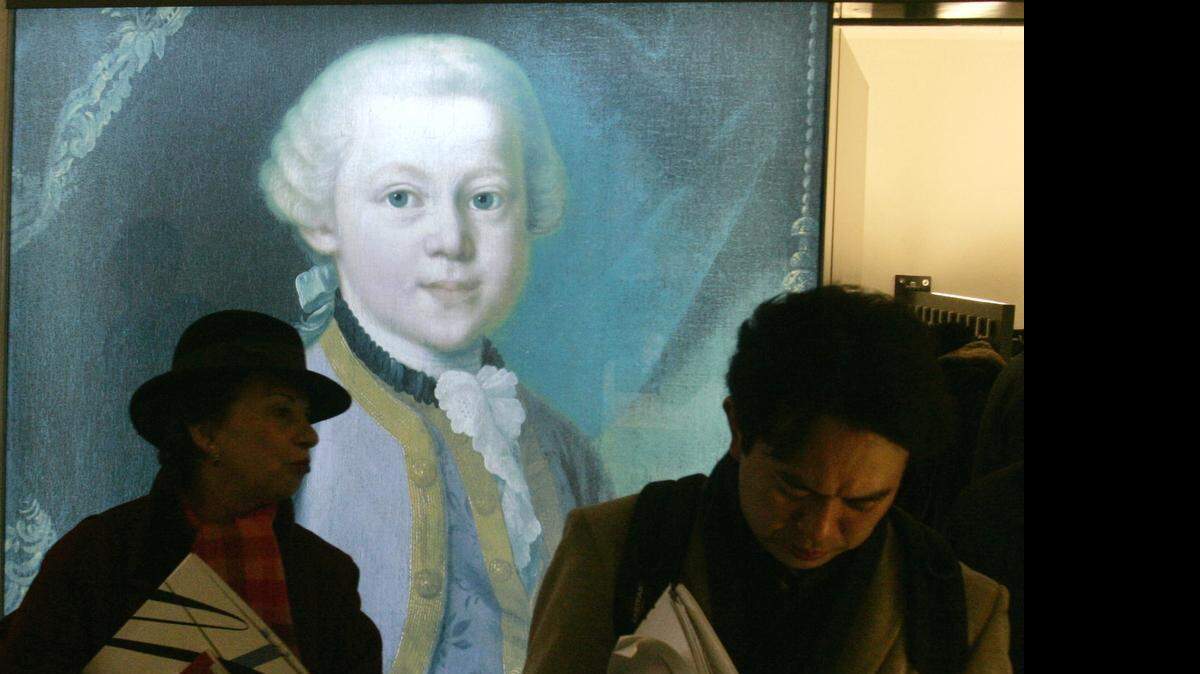 
Visitors walk past a Mozart poster during an exhibition at the Mozarthaus in Vienna. At the apartment in Domgasse 5, Wolfgang Amadeus Mozart lived from 1784 to 1787 composing “The Impresario” and “The Marriage of Figaro” and other major works.
