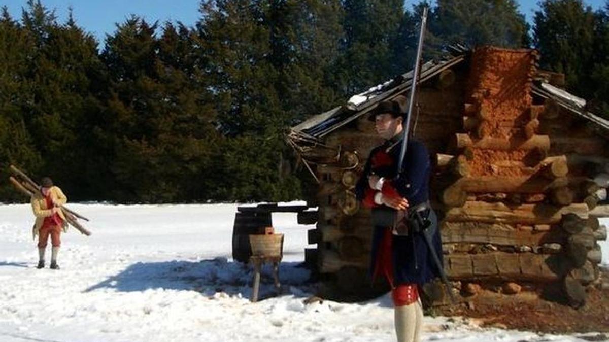 Fort Dobbs was a lonely place, especially in winter. One reenactor stands guard as another hauls firewood to their hut.