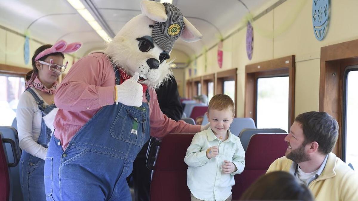 The Easter Bunny, dressed in overalls, distributes treats at the Easter Bunny Express.