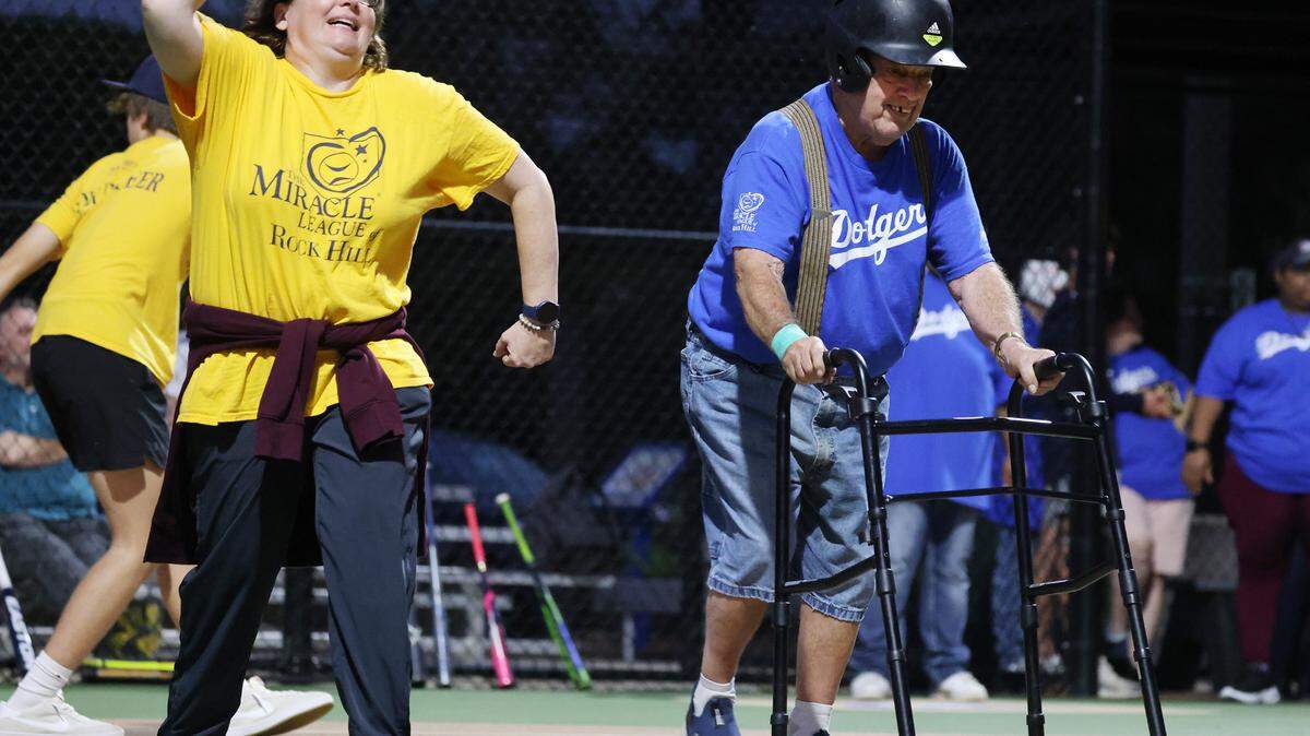 Larry Ferguson, 80, makes his way to first base after hitting the baseball Wednesday at the Miracle League game in Rock Hill. Cheering him on is Melissa Inzerillo.