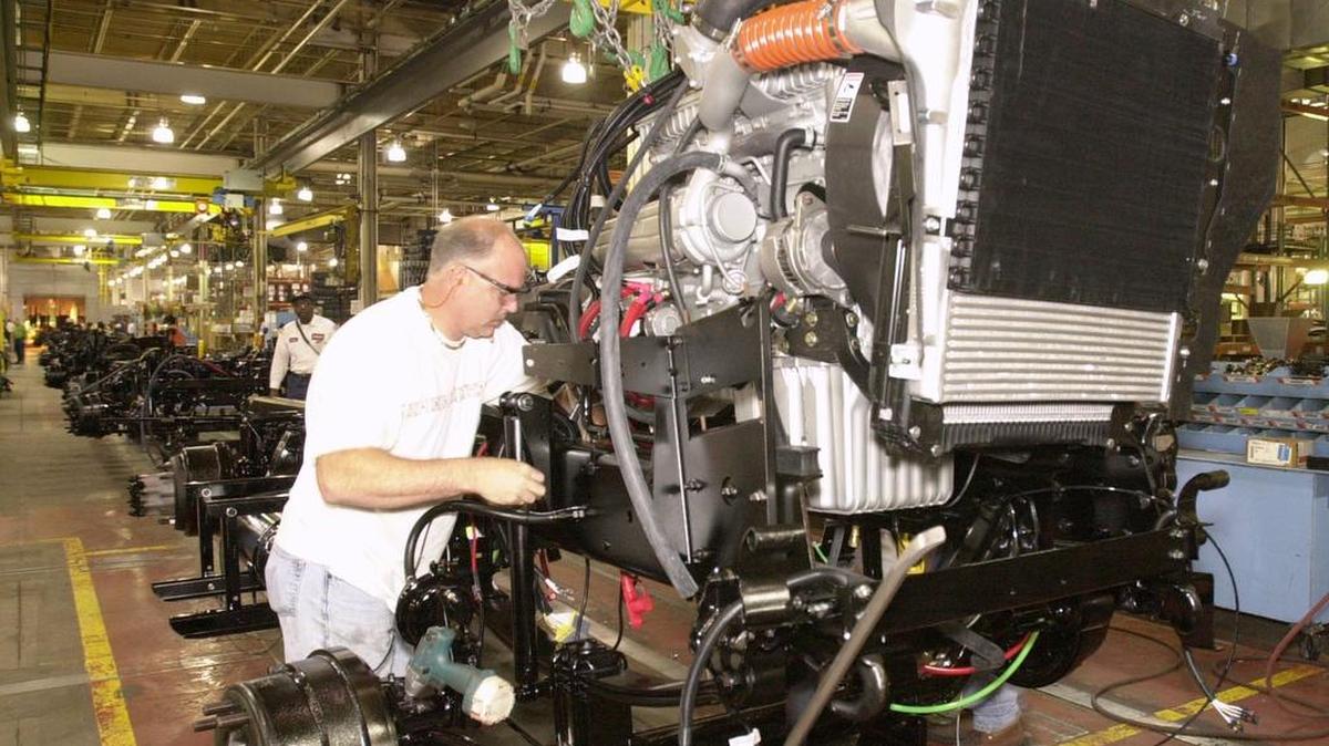 
A Daimler North America engine assembly line worker installs the engine for a Freightliner Business Class truck at the manufacturing plant in Mount Holly. The company will add 605 jobs to its Freightliner plant by mid-July. 
