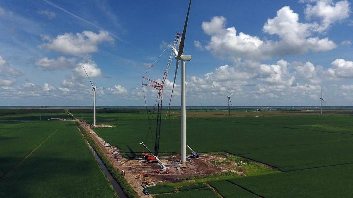 A crane holds the blade assembly as it is attached at the Amazon Wind Farm U.S. East near Elizabeth City.