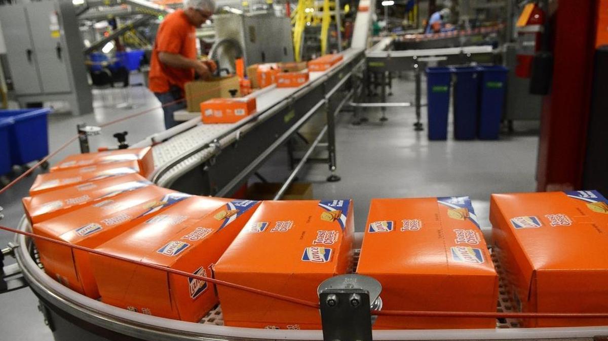 Cartons of Toast Chee head to being packed in cases for shipping on a tour of the Charlotte facility in 2015. The snack maker is considering selling itself after an approach by Campell Soup, CNBC first reported.