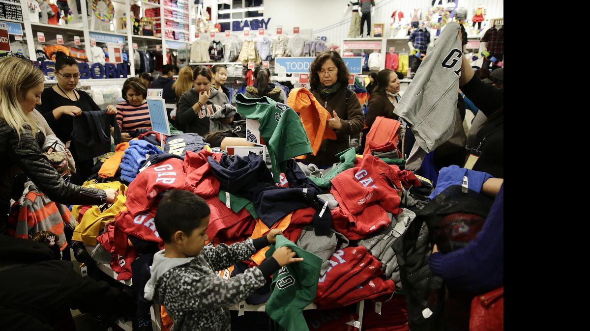 
People shop at a Gap factory store at the Citadel Outlets in Los Angeles in this 2013 photo. The National Retail Federation anticipates family budgeting will cause back-to-school spending to decline 5.8 percent this year. 
