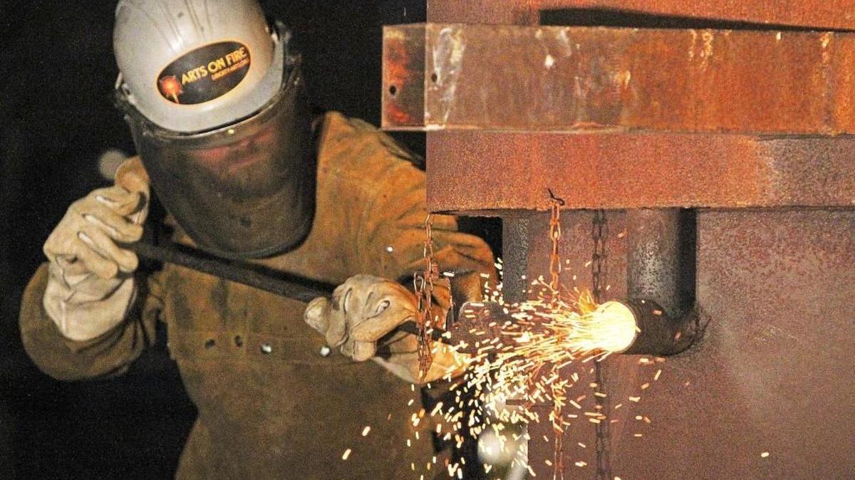 A worker stokes a furnace fire. The nonprofit Liberty Arts sculpture studio and foundry and Durham Central Park held a public iron pour in the park Friday night, Nov. 18, 2016. North Carolina’s unemployment rate inched upward for a third consecutive month even though the number of of people with jobs continued to grow.