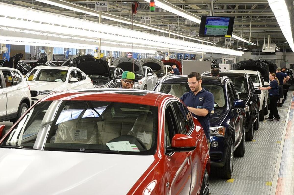 In this file photo, BMW team members in South Carolina clean and check finished cars in the finish line.