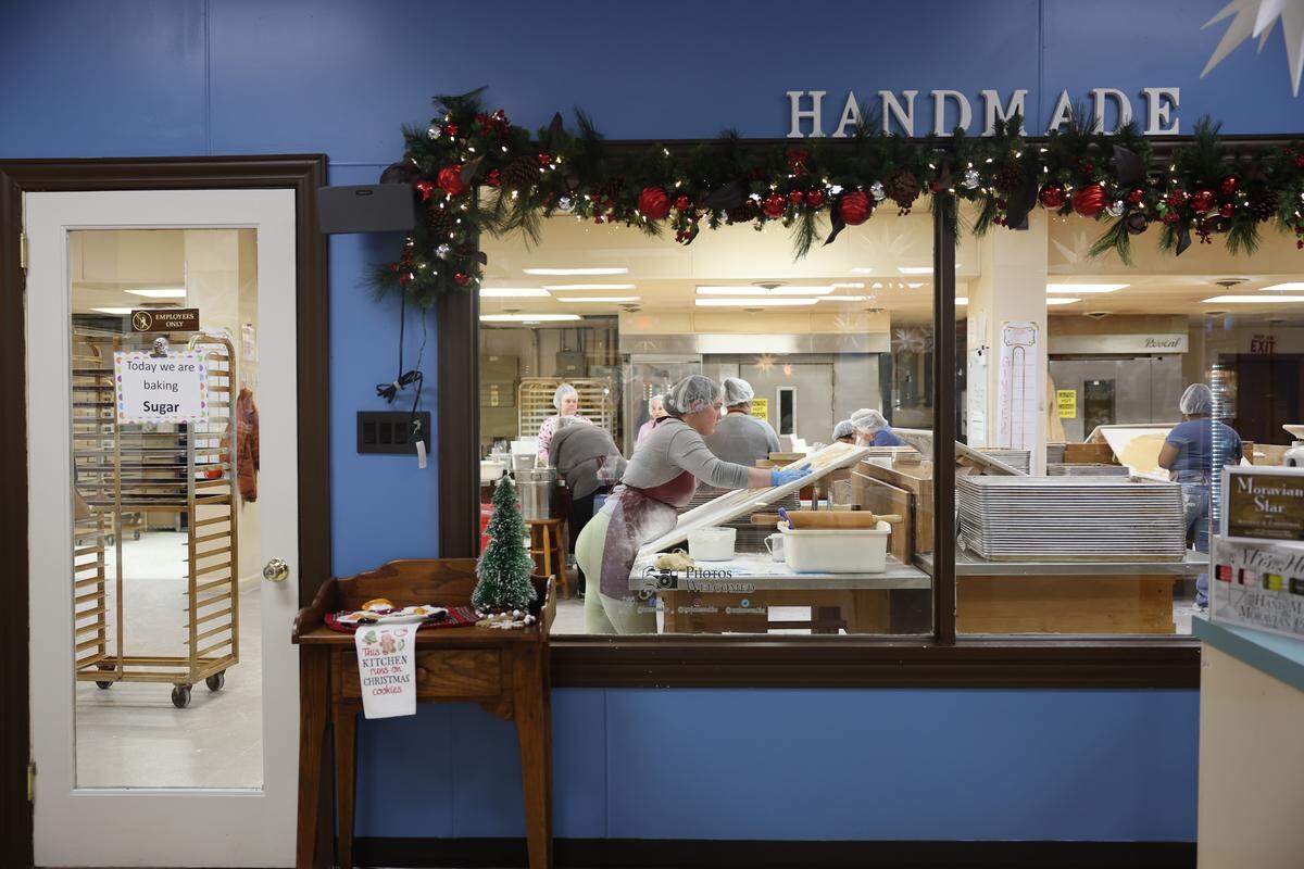 Workers at Mrs. Hanes’ Moravian Cookies, located in the Arcadia area of Davidson County, make sugar cookies near a window for visitors to see on Wednesday, Nov. 19.