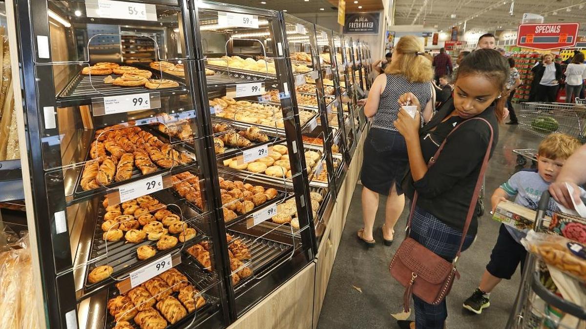 Shoppers look over the bakery display during the grand opening of a Lidl grocery store last month in Virginia Beach, Va. Lidl plans to have 100 stores open across the East Coast by next summer.