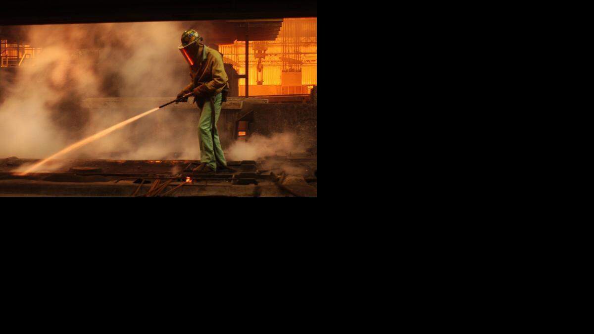 
A Nucor employee sprays water on molten steel at a plant in North Carolina.
