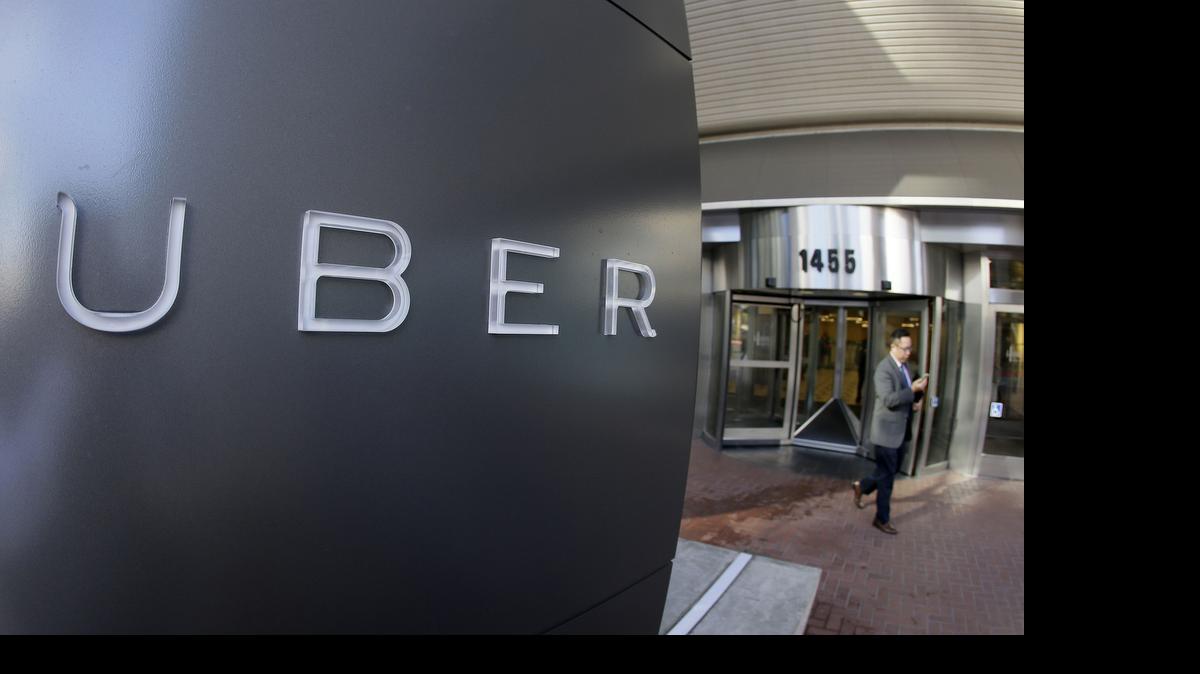 
FILE - In this photo taken Tuesday, Dec. 16, 2014, a man leaves the headquarters of Uber in San Francisco. (AP Photo/Eric Risberg, File)
