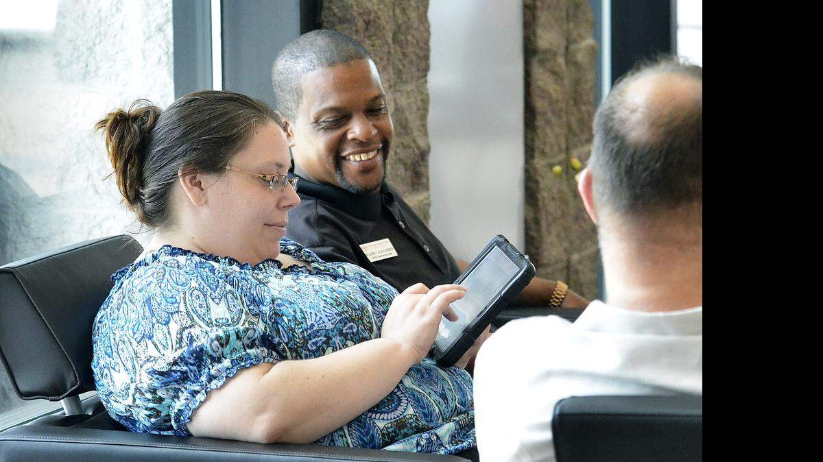 
In her search for just the right Toyota Highlander, Sue Kocik (left) uses an iPad with the help of Rodney Alexander, an Experienced Guide or EG, at Town & Country Toyota Wednesday. Sonic Automotive's new dealership model aims at being high-tech, efficient and fast. They say the way they use technology can enhance the customer experience and have them out of the door with the car they want within 45 minutes. Kiosks for different stages of the purchase and "imagine bars" equipped with iPads were in use on Wednesday May 20, 2015.
