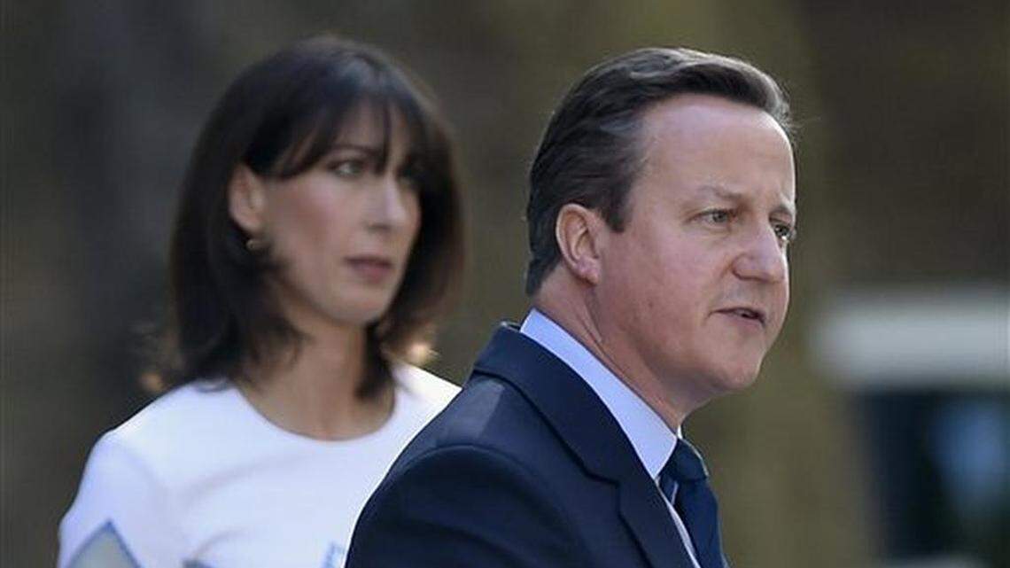 Britain's Prime Minister David Cameron speaks outside 10 Downing Street, London as his wife Samantha looks on Friday, June 24, 2016. Cameron says he will resign by the time of party conference in the fall after Britain voted to leave the European Union after a bitterly divisive referendum campaign, according to tallies of official results Friday. (Lauren Hurley/PA via AP) UNITED KINGDOM OUT, NO SALES, NO ARCHIVE