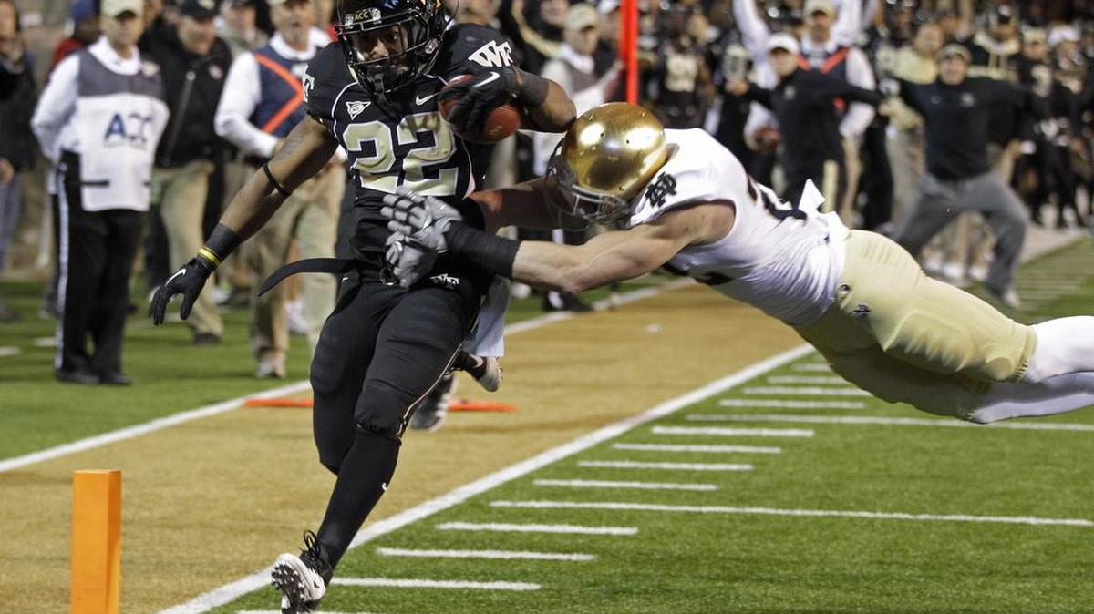 Wake Forest University will play the University of Notre Dame in 2020 at Bank of America Stadium in Charlotte. In this 2011 photo, Wake Forest’s Brandon Pendergrass, left, runs in for a touchdown past Notre Dame’s Harrison Smith.