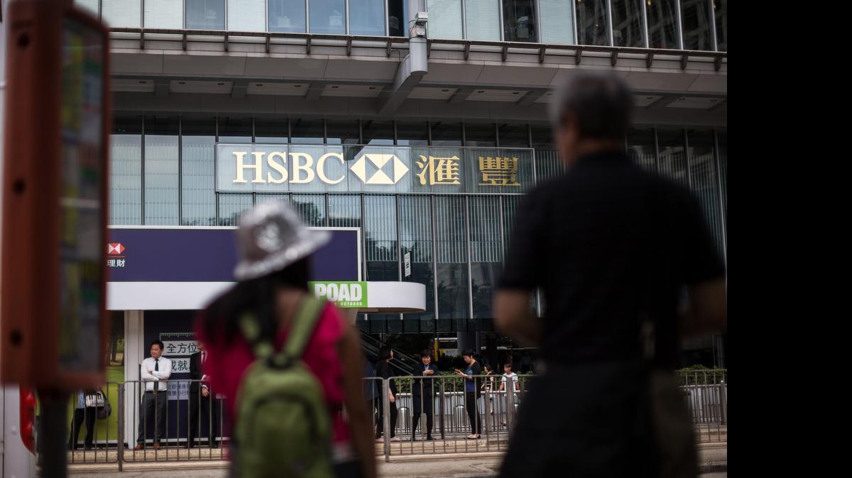 
Pedestrians stand in front of the HSBC Holdings Plc headquarters building in Hong Kong, China, on June 9. HSBC will eliminate as many as 25,000 jobs through 2017 as CEO Stuart Gulliver seeks to cut annual costs by about $5 billion to restore profit growth. 
