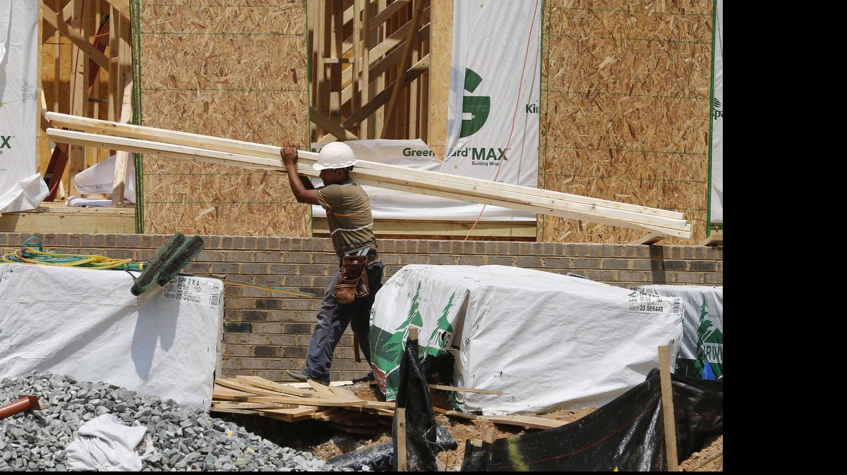 
A worker carries a load of lumber at a new home construction site in Mechanicsville, Va. 

