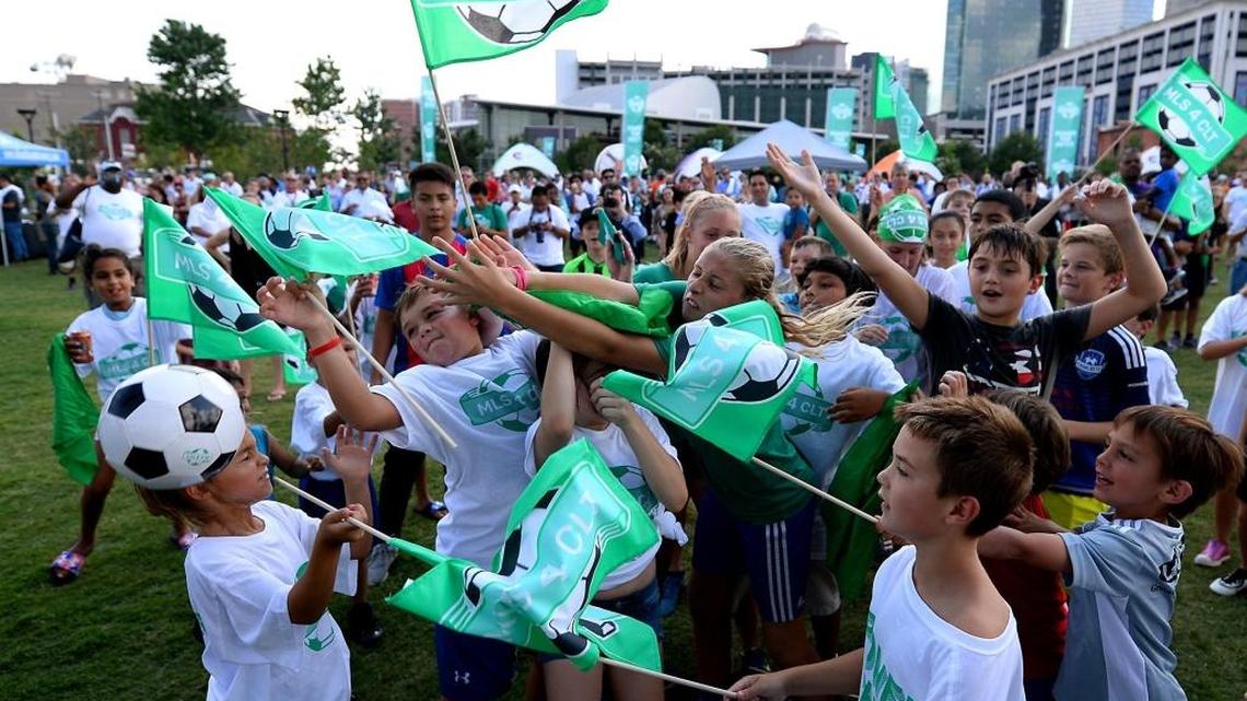 Children gather near the stage in an attempt to grab free MLS soccer balls during the MLSCLT rally at First Ward Park in Charlotte, NC on July 18, 2017.