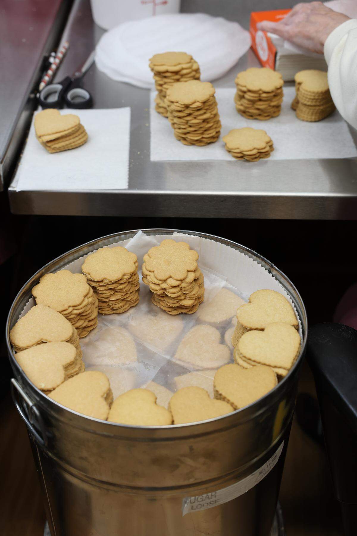 Workers take cookies from barrels to put in tins for shipping Wednesday, Nov. 19, at Mrs. Hanes’ Hand-Made Moravian Cookies.