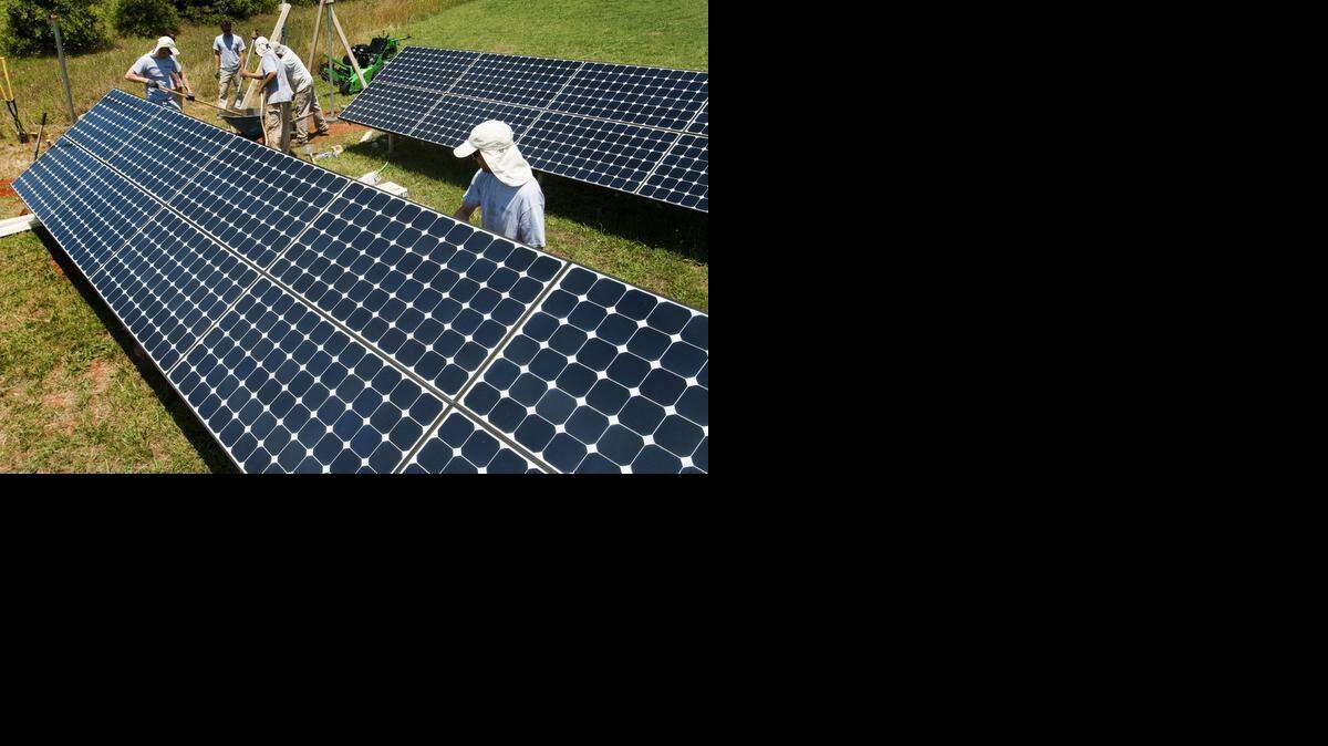 
A crew from Argand Energy Solutions installs hardware for solar arrays at an airport in Ellenboro. Federal law obligates utilities to buy renewable energy. State law says green-energy developers have to sell to utilities, not directly to customers, although a push is underway to allow third-party sales.
