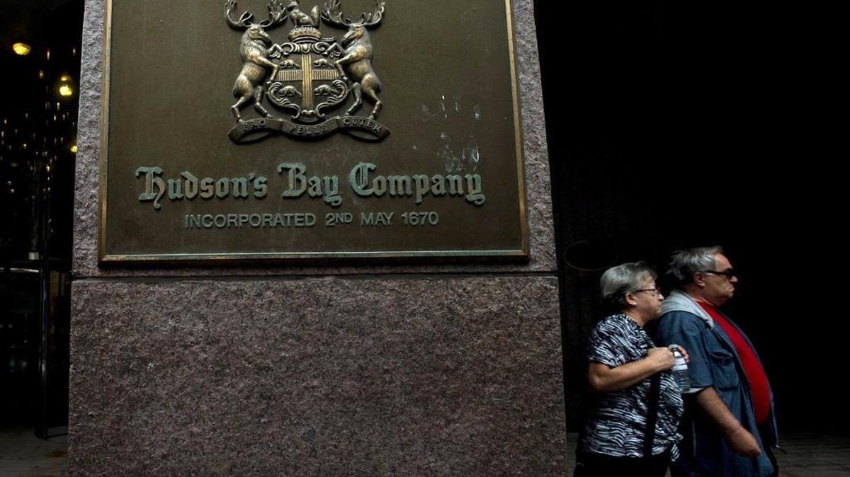 In this July 29, 2013, file photo, people walk past a Hudson's Bay Co. store sign in Toronto. Hudson Bay reported Thursday, Jan. 7, 2016, they have purchased the luxury deal site Gilt Group Holdings Inc. for $250 million as traditional retailers follow shoppers, and their money, online. (Nathan Denette/The Canadian Press via AP, File)