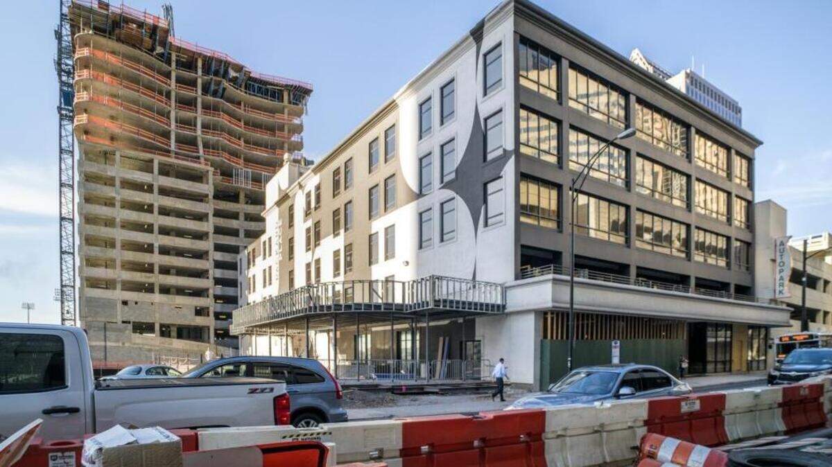 A new apartment building rises behind Packard Place in uptown, built partly on land that once was part of the entreprenuerial hub’s property. The initial 2010 purchase of Packard Place by Dan and Sara Roselli has been an issue in a long-running bankruptcy case.