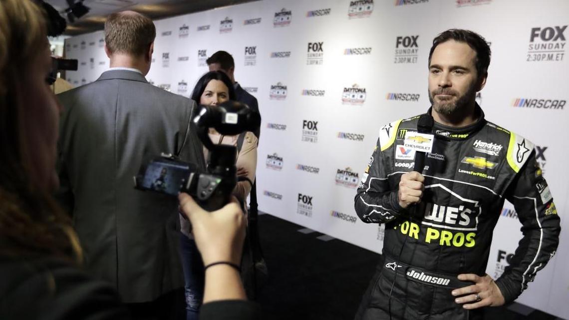 Jimmie Johnson, right, answers questions during media day for the NASCAR Daytona 500 auto race at Daytona International Speedway Wednesday.