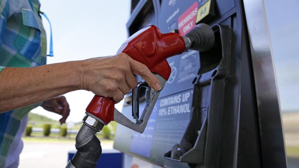 
A woman holds a nozzle as she refuels her car at a Costco gas station in Robinson Township, Pa., in this July photo. 
