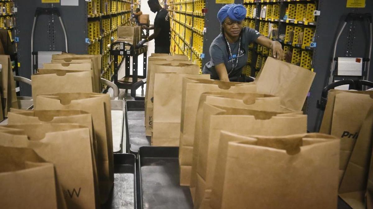 In this Dec. 21, 2016, file photo, Miracle Stewart, right, an employee of Amazon PrimeNow, prepares bags to fill with orders from customers making purchases, at a distribution hub in New York. The e-commerce giant won approval from Kannapolis City Council Monday night for a new 1 million square-foot, $85 million distribution center.