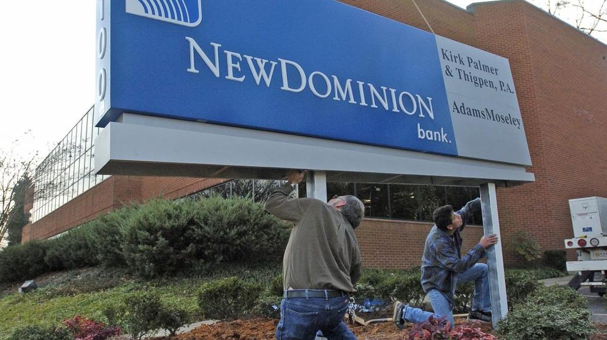 Workers install the new sign for NewDominon Bank ahead of its 2005 opening.