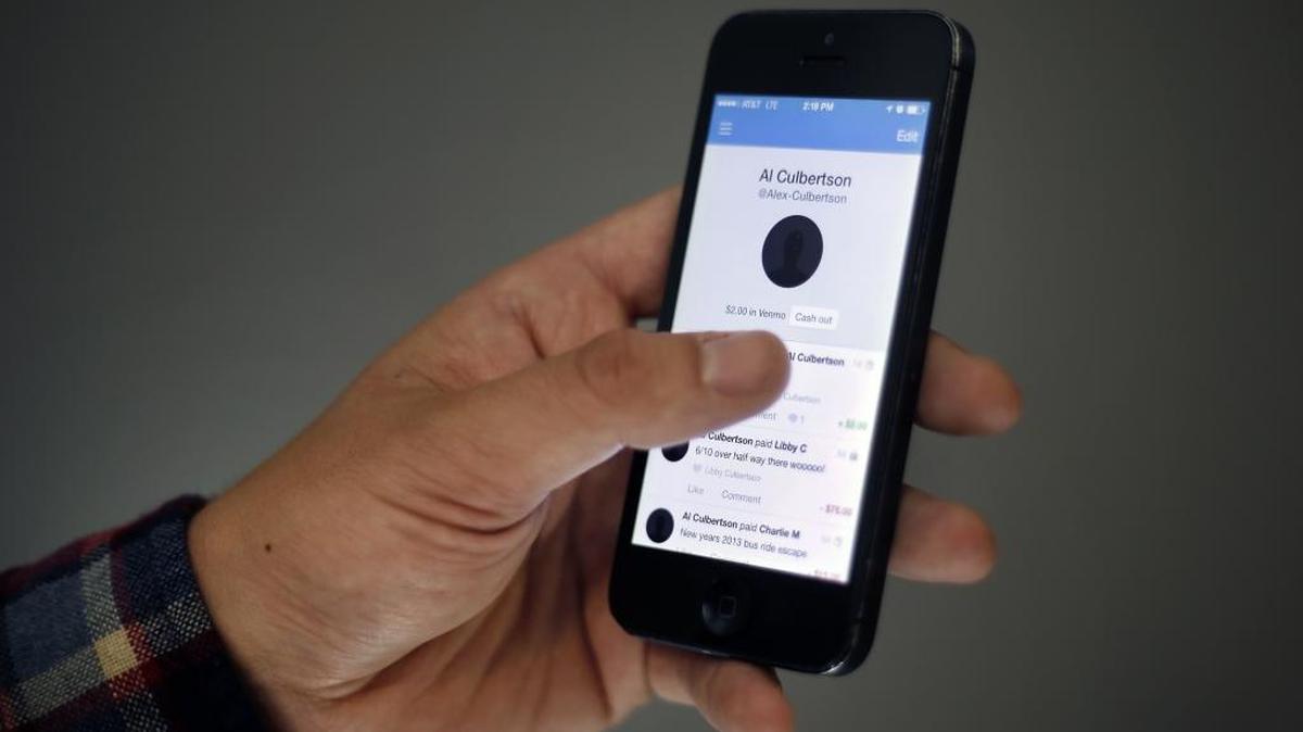 In this file photo, Alex Culbertson, 26, shows transactions via the Venmo app on his smartphone.