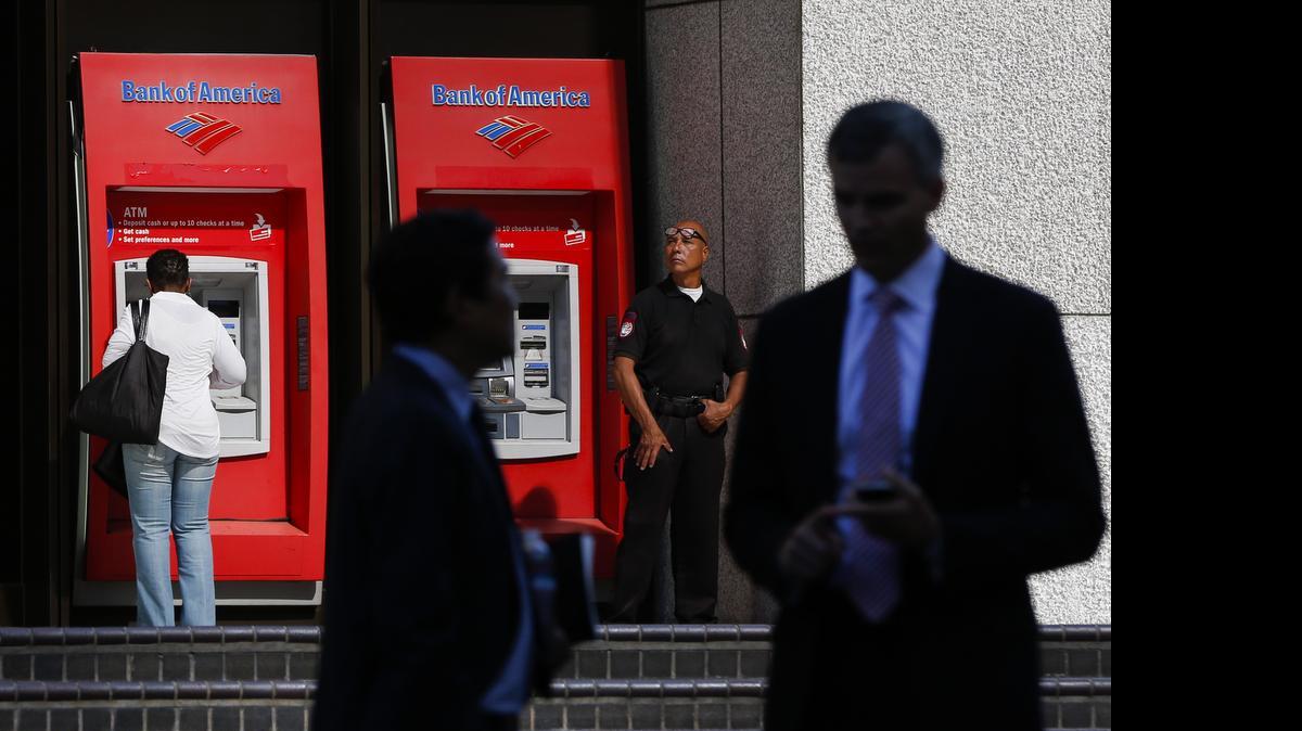 
A security guard stands in front of Bank of America ATMs outside of the Bank of America Plaza tower in Los Angeles.

