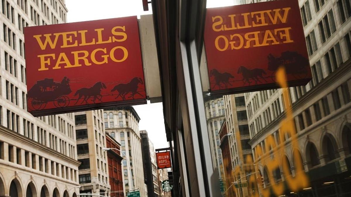 People walk by a Wells Fargo branch in New York in October. A federal regulator has told Wells’ board it is considering an enforcement action against the bank over practices in its mortgage and auto lending businesses, the Wall Street Journal reported Wednesday.