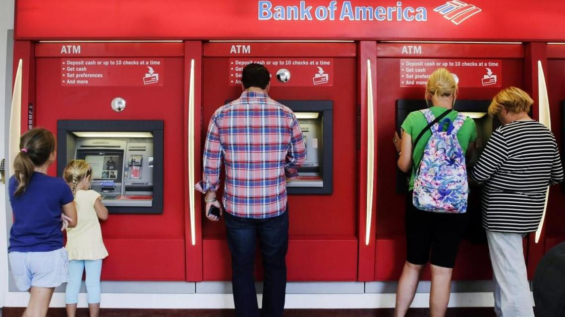 In this 2015 file photo, customers use automated teller machines at a branch office of Bank of America in New York.
