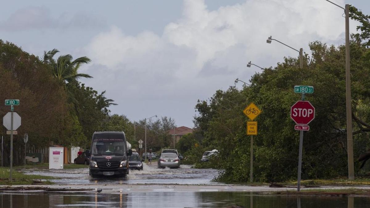 Cars make their way through flooded streets at the intersection of Southwest 180th Street and 142nd Avenue in Richmond West, Florida on Monday.