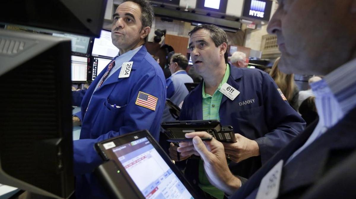 Specialist Jorge Fernandez. left, works with traders Daniel Trimble, center, and Mark Muller on the floor of the New York Stock Exchange, Friday, June 3, 2016. Stocks are broadly lower in early trading and bond prices are higher after the government reported a sharp slowdown in hiring last month.