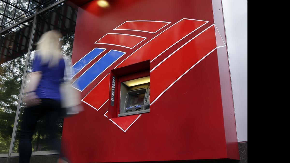 
A woman walks past a Bank of America ATM in downtown Charlotte.
