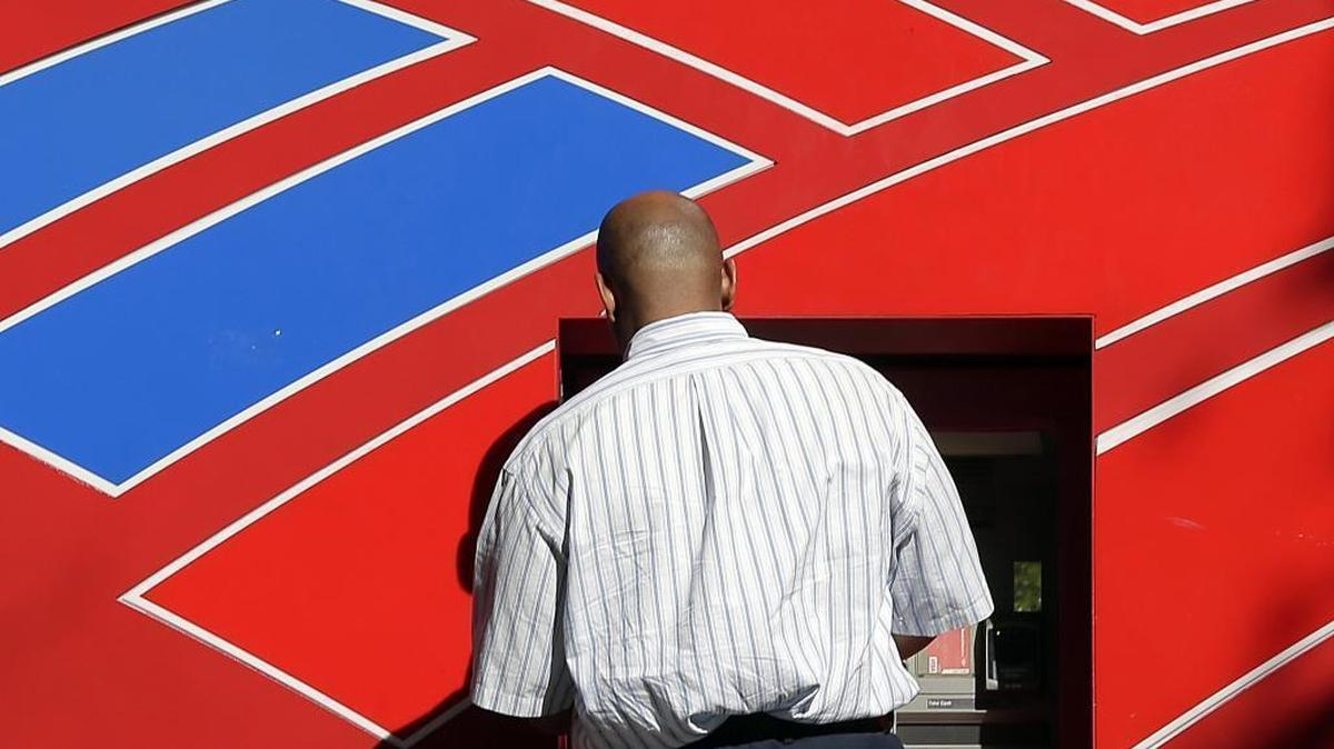 A man uses a Bank of America automated teller machine near the company’s headquarters in Charlotte in this April 2017 photo.