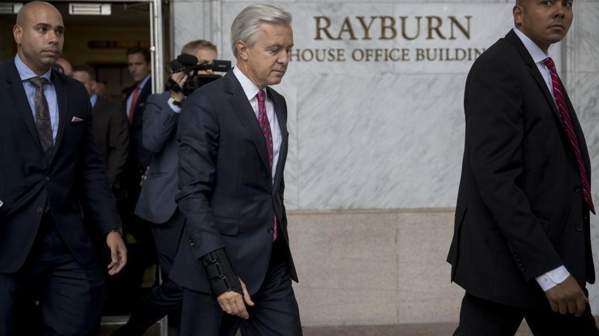 John Stumpf, chief executive officer of Wells Fargo & Co., center, exits the Rayburn House Office building after a House Financial Services Committee hearing in Washington, D.C., U.S., on Thursday, Sept. 29, 2016.