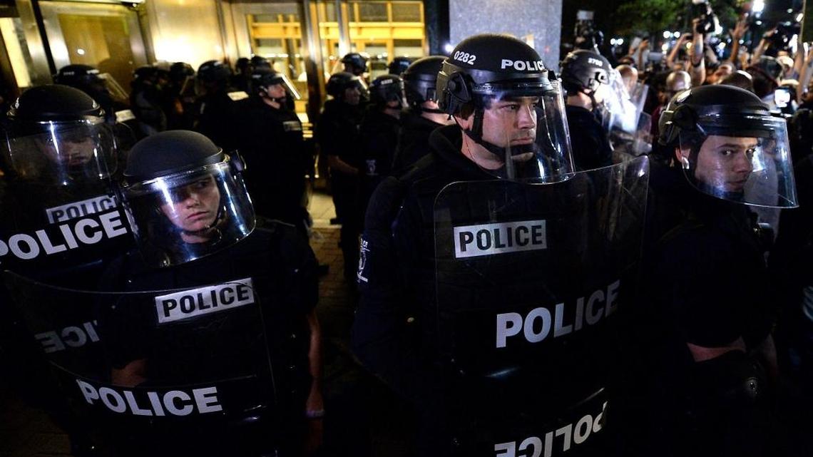 Police officers in riot gear stand at the ready near Trade and Tryon Streets in Charlotte, NC on Thursday.