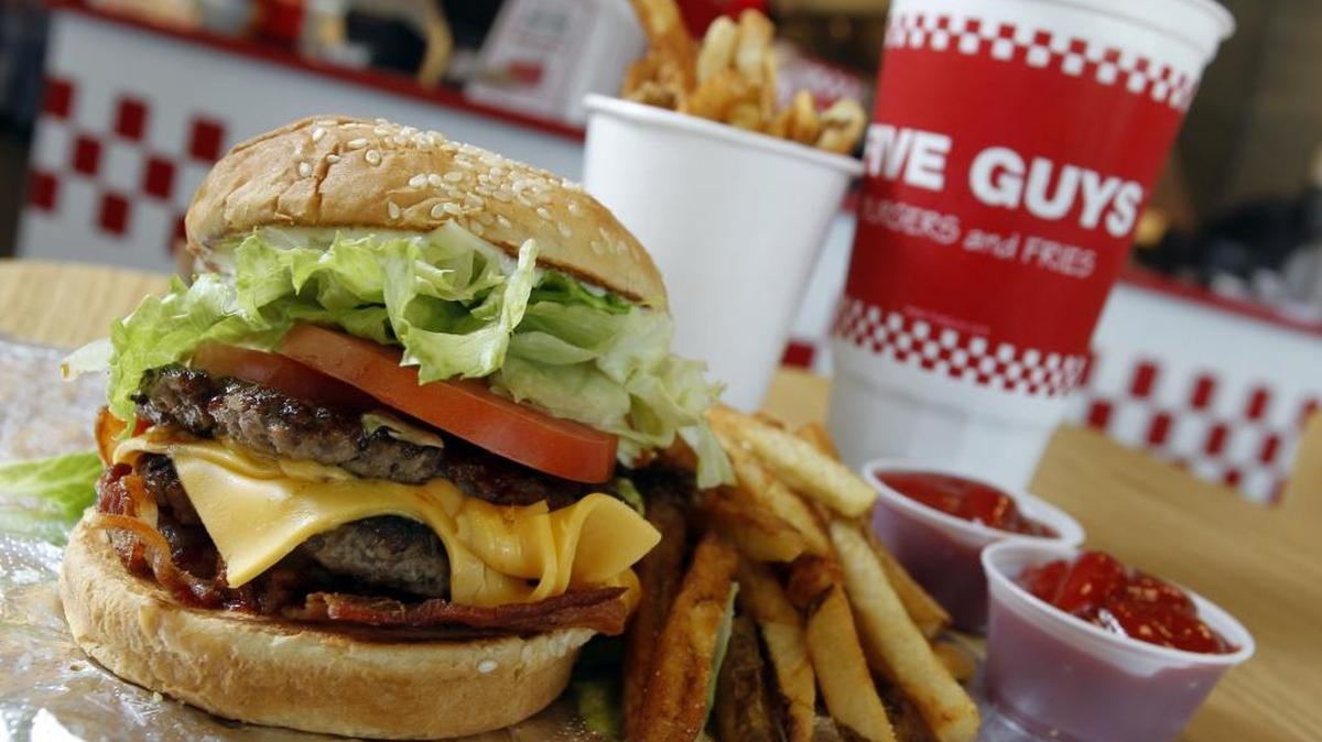 A double patty cheeseburger with lettuce, tomato, bacon barbecue sauce and mayo with fries and a drink at a Five Guys Burgers and Fries on South Hulen in Fort Worth.