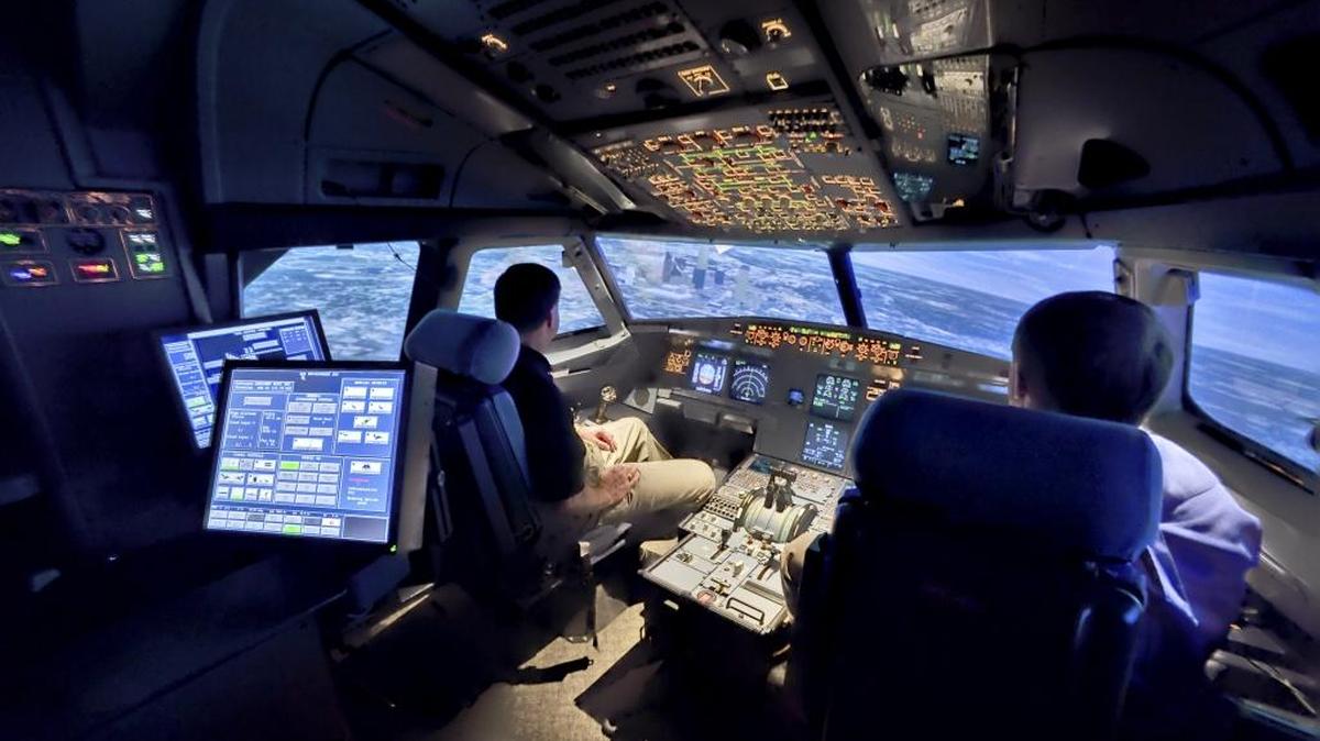 Inside the simulator, a 240-degree projection screen can visually place the pilots anywhere the airline flies, changing the scene as the "plane" changes speed, direction and altitude. In this photograph, uptown Charlotte is outside the left center window.